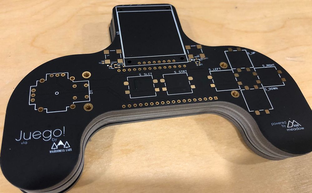 Photo of a PCB shaped like a joystick with several component through-holes and surface-mount pads.