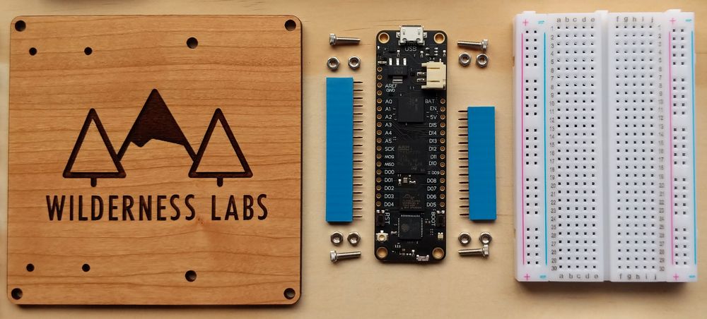 Meadow developer kit parts: mounting protoboard, Meadow board with headers and mounting hardware, and small breadboard.